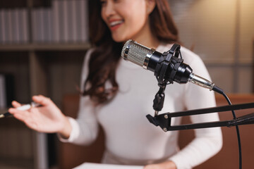 Woman presenting podcast during online broadcasting at studio
