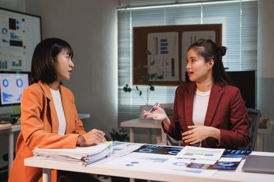 Business women analyzing data and discussing strategy in office