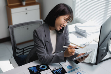 Asian businesswoman analyzing financial data while talking on phone