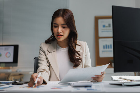 Professional businesswoman analyzing financial report document in office