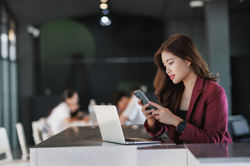 Young woman engaging with smartphone at modern office