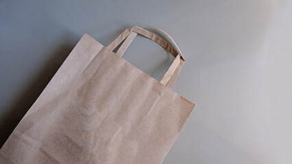 Eco-friendly brown paper bag with handles on white background