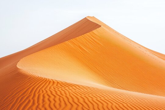 Orange sand dune peak with rippled texture against a bright, neutral sky