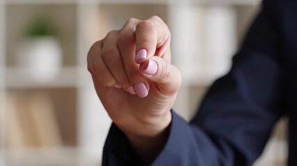 Close-up of female hand with pink nails making a precise gesture, indicating small detail or holding invisible object
