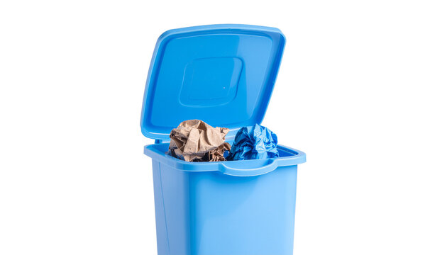 Blue plastic trash can with an open lid containing crumpled paper and other waste material, centered in the frame. solid white background