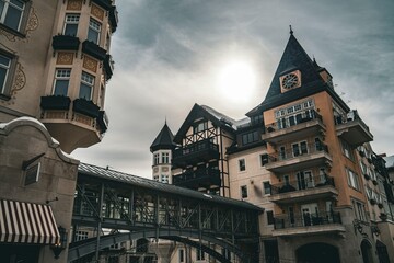 Historic European architecture in a charming old town square under a dramatic cloudy sky showcasing intricate building details and balconies