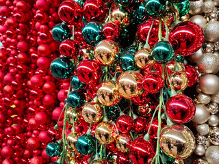 christmas tree decorations baubles on the wall in the colors red, gold and green.