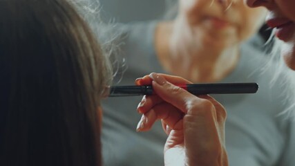 Brunette woman with long hair and grey eyes in a beauty salon during a makeover session