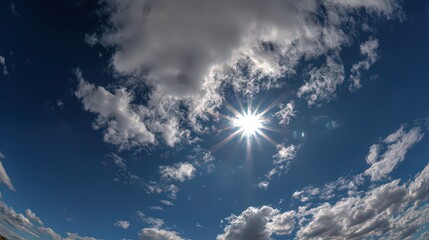 Bright Sun Shining Through White Clouds in Deep Blue Sky Low Angle View Cloudscape with Sunbeams and Wispy Cloudscape Atmospheric Optics Sunlight
