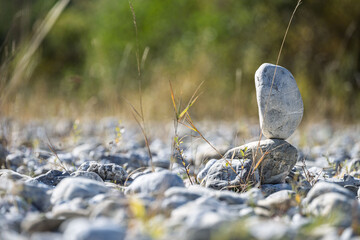 Stacked stone cairn with a colorful autumn background, featuring warm fall foliage and natural rock textures in a serene outdoor landscape.