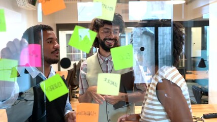 Diverse coworkers brainstorming project ideas with sticky notes - Powered by Adobe