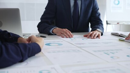 Business professionals discussing financial reports and marketing charts during corporate meeting, focusing on strategy, planning, data analysis, and teamwork - Powered by Adobe