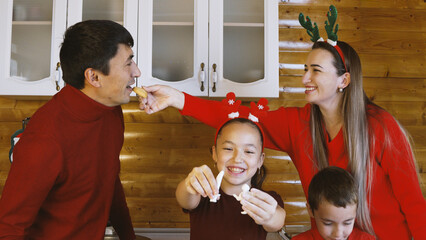 A family is enjoying time together baking in the kitchen for Christmas