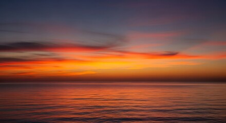 Fototapeta premium Vibrant sunset over calm ocean waters reflecting colorful sky.