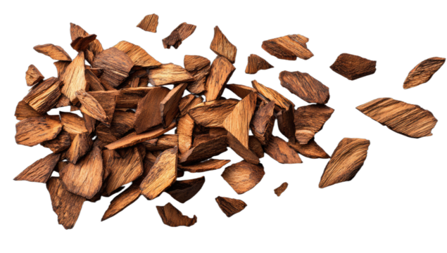 A pile of dark brown wood chips, some scattered, viewed from above on black