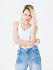 Asian confident beautiful attractive young woman blonde long hair stand wear sleeveless top jeans on white background studio, portrait lifestyle fashion street outfit trendy style pose look at camera.