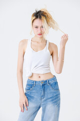 Asian confident beautiful young woman blonde hair high tied  standing wearing sleeveless top jeans...