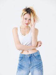 Asian confident beautiful young woman blonde hair high tied  standing wearing sleeveless top jeans on white background studio portrait lifestyle fashion street outfit trendy style pose look at camera.
