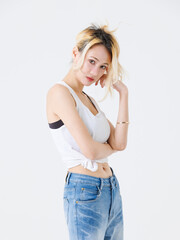 Asian confident beautiful young woman blonde hair high tied  standing wearing sleeveless top jeans...