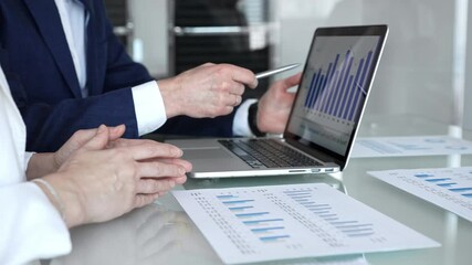 Businesspeople hands gesturing and reviewing contracts on a glass table during an important negotiation, concluding a deal in a professional corporate environment