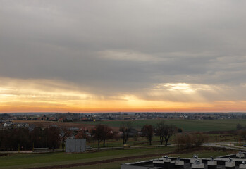 Obraz premium The radiant glow of the setting sun breaking through the thick cloudy sky, visible rays of sunlight