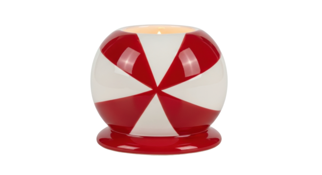 A lit candle glows warmly inside a glossy ceramic holder featuring a festive red and white pinwheel pattern, creating a cozy and decorative ambiance for the holiday season