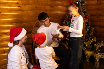  family celebrates Christmas near the tree, giving the children a white rabbit