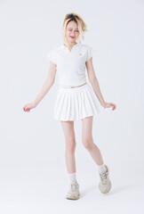 Naklejka premium Asian confident attractive beautiful woman blonde hair tied stand wear white shirt top mini skirt sport on background studio portrait fashion street outfit trendy style pose look at camera full length