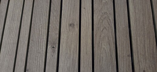 Aligned wooden planks, weathered by time and the elements. Their gray-brown tone and natural grain...