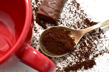 Ground black coffee scattered on white background.