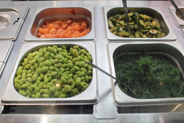 Beans, cucumbers and seaweed in a salad bar. Vegetables for salad