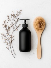 A black pump bottle and a wooden hairbrush are arranged with dried plant sprigs on a white textured surface.