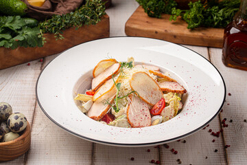 Fresh Caesar salad with grilled chicken slices crunchy lettuce tomatoes and parmesan on a white plate