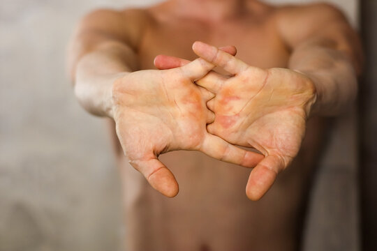 Muscular man performing finger interlock stretch with palms facing out
