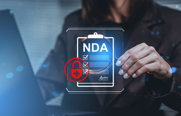 Businesswoman analyzing NDA document with digital lock icon representing data privacy and confidentiality concept on futuristic blue background.