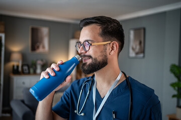 Male healthcare worker drinking water taking break