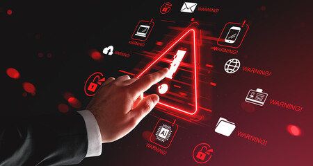 Cybersecurity threat warning concept with hand touching red alert symbol on digital interface surrounded by security icons on dark background.
