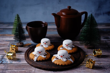 Gingerbread cookie with melting snowman topping on a wood background