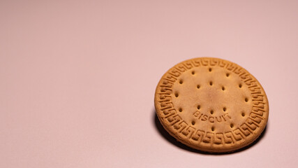 Close-up view of the classic sweet cracker, emphasizing its golden-brown color, crispy texture, and embossed pattern detail.