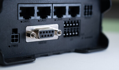 Rear panel of black industrial network router with multiple ports, featuring LAN, WAN, RS232, and I/O ports on a clean white background.