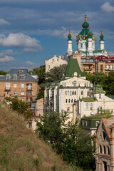 Obraz premium Majestic baroque St Andrew's Church with green domes rises above historic buildings on Andriivskyi Descent in Kyiv Ukraine creating a beautiful famous capital city landmark landscape view