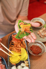 Korean BBQ with pork belly, vegetables, and rice, banchan, and other Korean appetizers at a restaurant. Fermented food