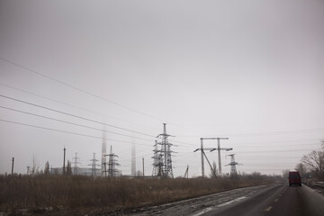 High voltage electric transmission towers stand in the fog near the Kurakhove Thermal Power Plant in Donetsk region under a gloomy grey sky during the war against Russian aggression in Ukraine
