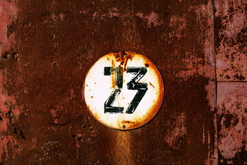 Vingt trois. Numéro 23. Plaque de numéro de rue sur fond rouillé.