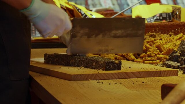 Close Up of Vendor Cutting Traditional Chinese Sesame Seed Candy