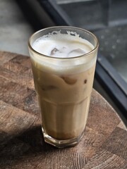 Coffee latte in a transparent glass on the table
