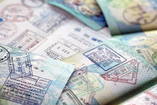 Many open passport pages with lots of visas and entrance stamps from various countries passport control. Concept of travel and tourism worldwide