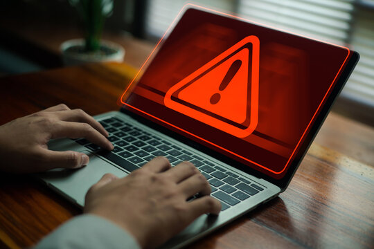A cyber warning alert displayed on a laptop screen as a user types, representing system risk, cybersecurity threats, data protection, and digital security awareness for modern technology.