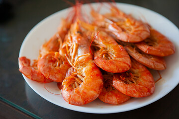 Cooked shrimp arranged on a white plate, showcasing fresh seafood texture and vibrant color. A simple, appetizing close-up ideal for culinary, nutrition, and seafood-themed content.