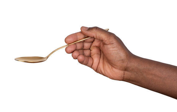 Hand holding a gold tablespoon isolated on white or transparent background	